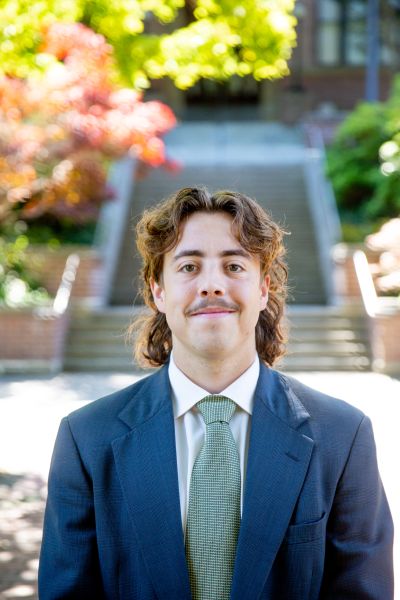 Student Trustee Max Stone. Standing in front of Old Main steps at Western Washington University